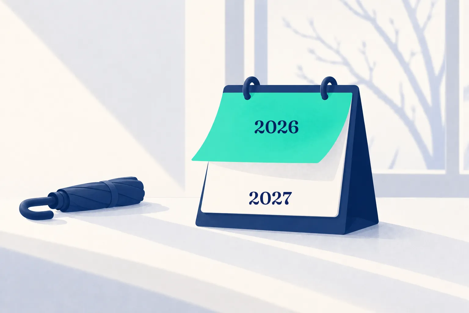 Ein navyblauer Tischkalender, dessen mintfarbenes Blatt 2026 sich umblättert und 2027 freigibt, daneben ein geschlossener Schirm im Winterlicht.